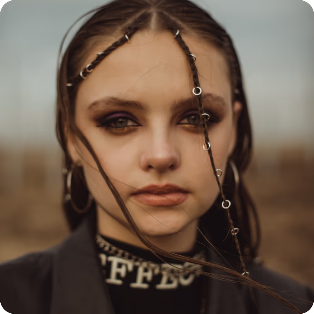 Image of a  woman with braided hair adorned with various piercings, showcasing a unique and stylish appearance.